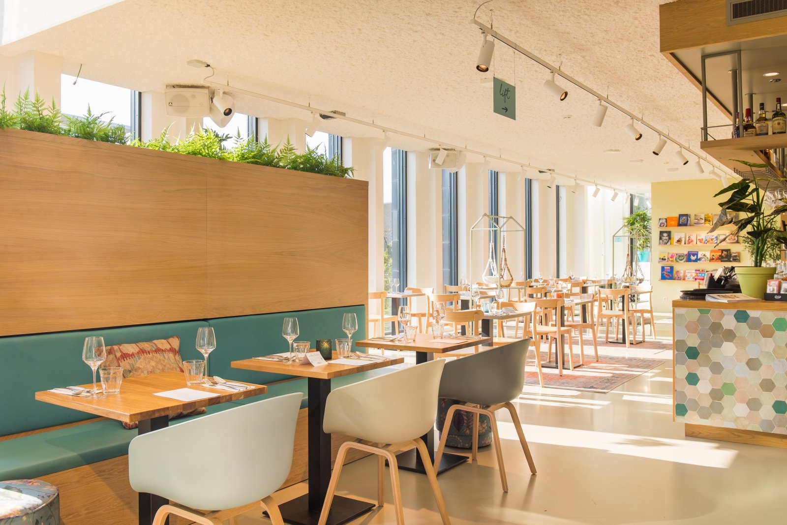 Restaurant Noda in Utrecht met houten scheidingswand, planten en lichte stoelen