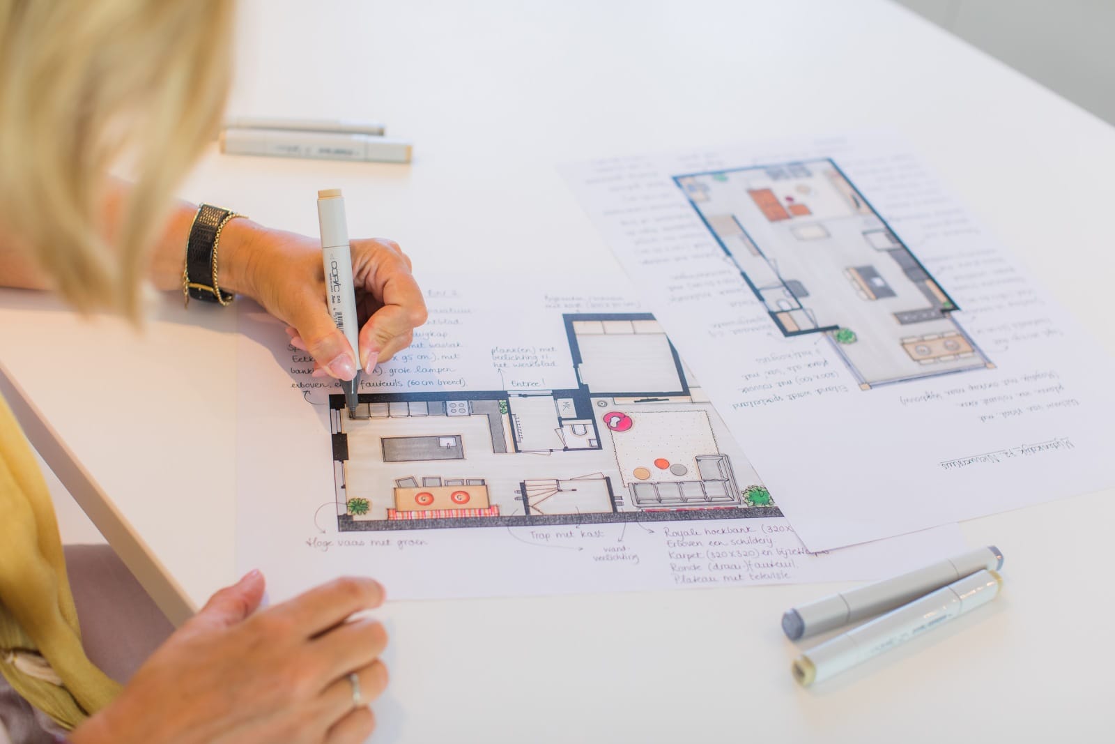 Luciënne tekent met stift een plattegrond uit op papier